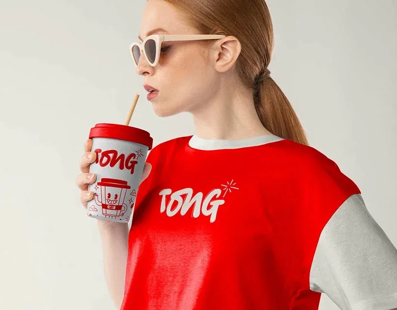 Wolfpixel’s TONG coffee lettering applied consistently to a takeaway cup and a red-and-cream shirt.